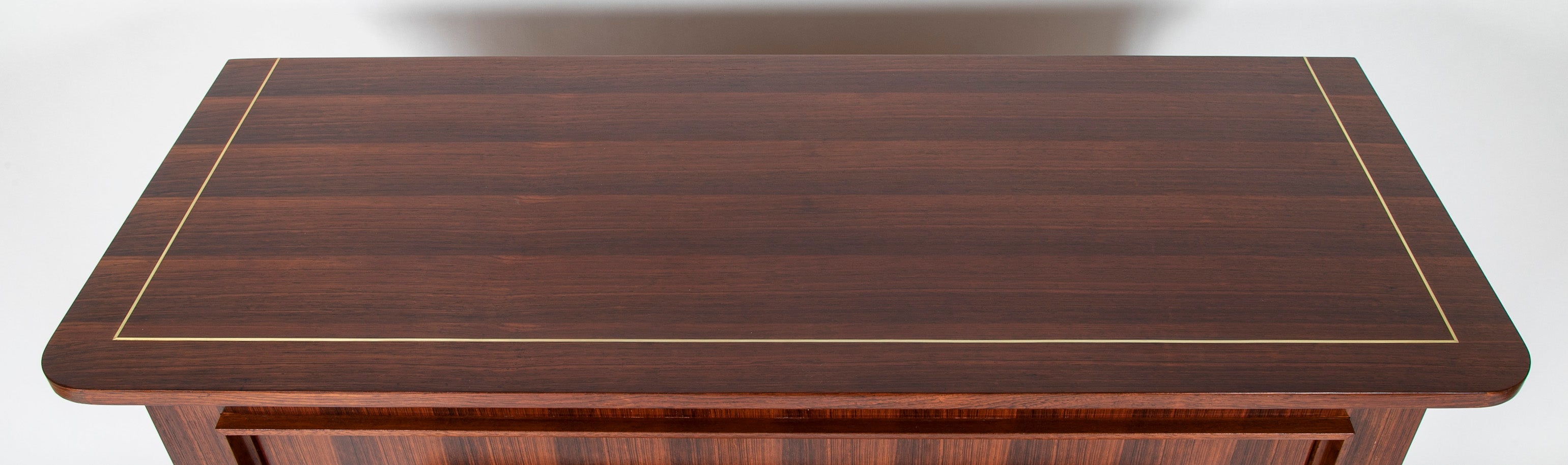 A Three Drawer Rosewood Commode in the Manner of Jacques Adnet
