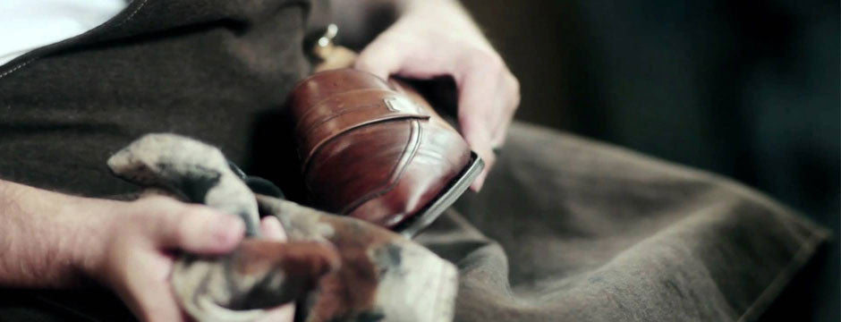 Person polishing a brown leather shoe