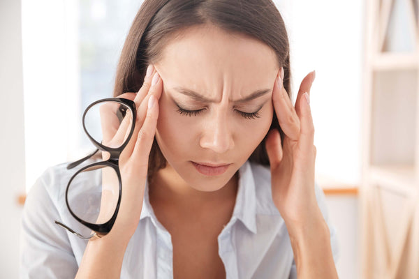 Une femme souffrant de maux de tête – symptôme d'intolérance à l'histamine