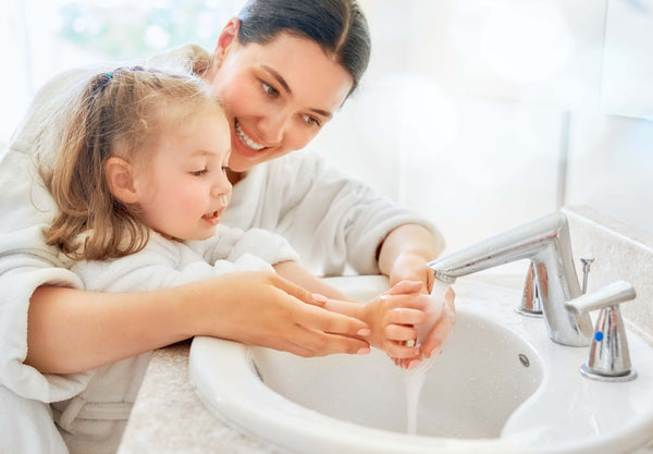 Mutter und Tochter waschen Hände: Vor Erregern schützen durch Hygiene