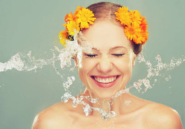 Frau mit schöner Haut bekommt Wasser ins Gesicht
