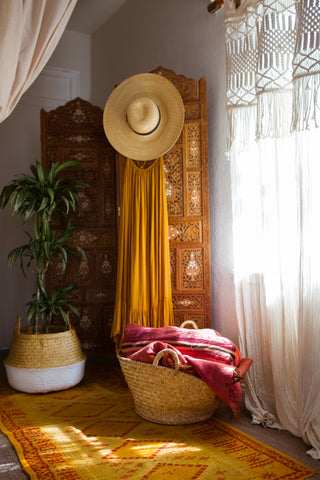 moroccan inspired home decor featuring a yellow and red rug, wooden screen and baskets for basket finds with La Basketry