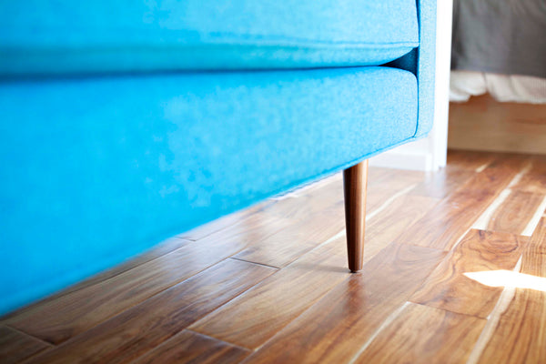 Extra long wood cone legs give the sofa a mid century look