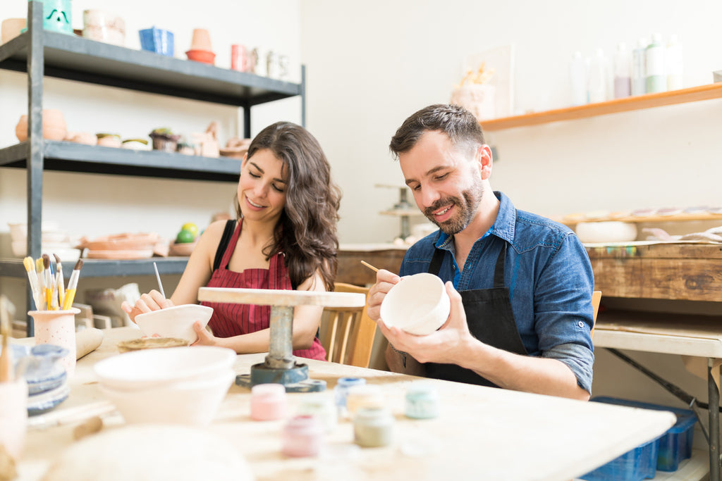 two adults taking a pottery class
