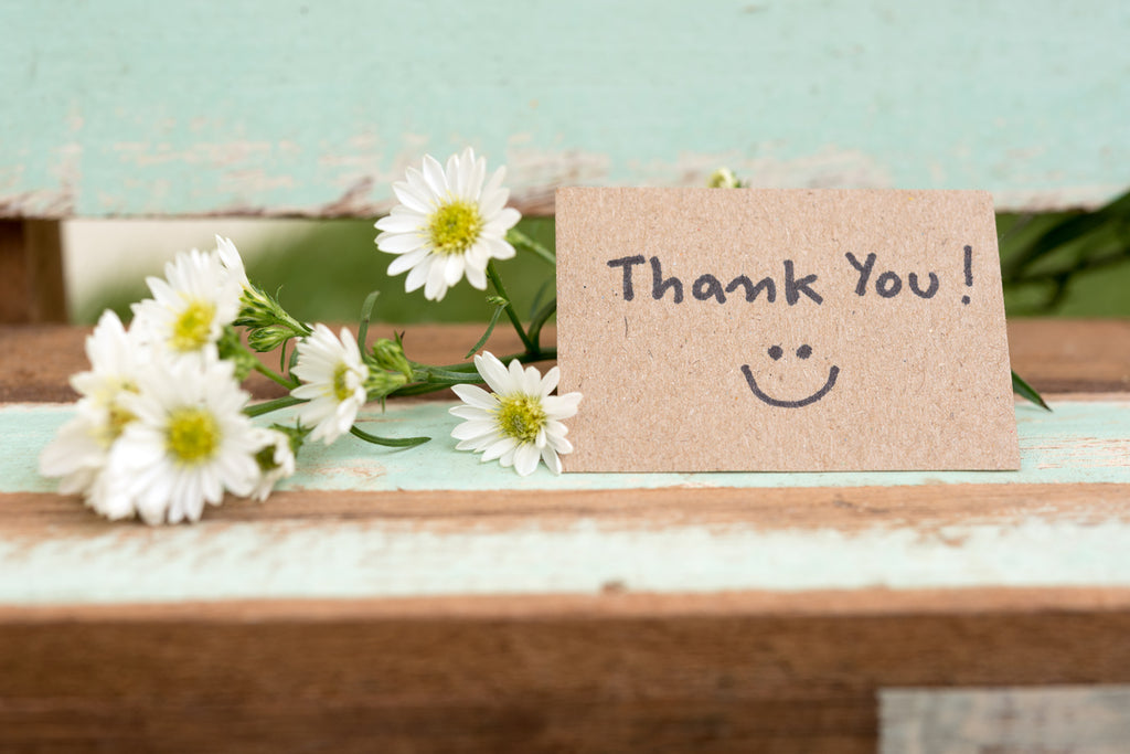 thank you card sitting in front of flowers