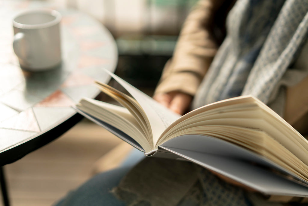 woman reading book in coffee shop