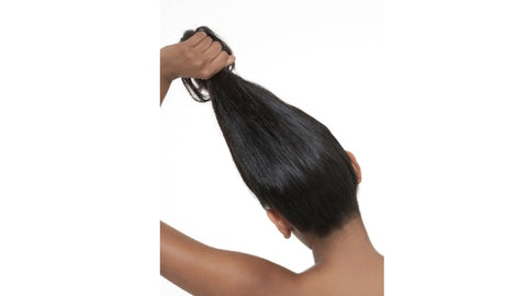 black woman holding hair up and showing crown and back of edges and hair line 