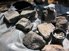 How to build a water garden pond - use smaller rocks as shims to hold the larger rocks in place.