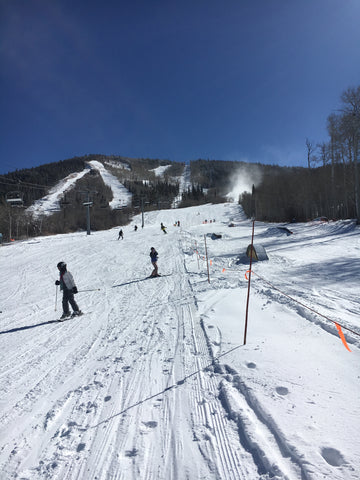 People skiing and boarding down the mountain