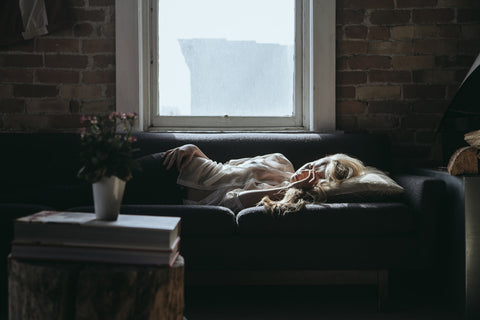 Woman lounging on the couch sad