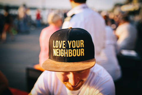 Man wearing a hat that says "love your neighbour"
