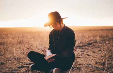 Person reading a book in a field