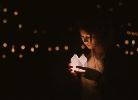girl holding a lantern in the dark