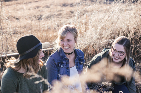 friends laughing together in a field