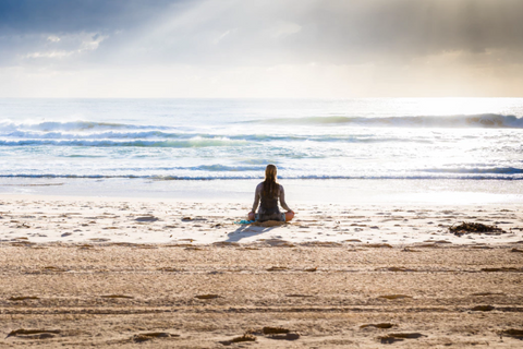 Person meditating on the beach