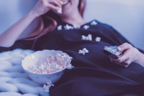 woman on couch eating popcorn