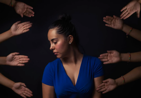 woman surrounded by hands