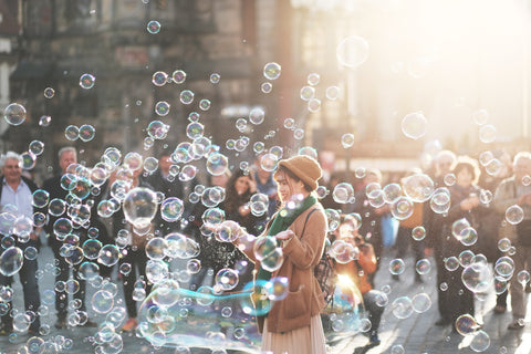 Girl blowing bubbles in the city