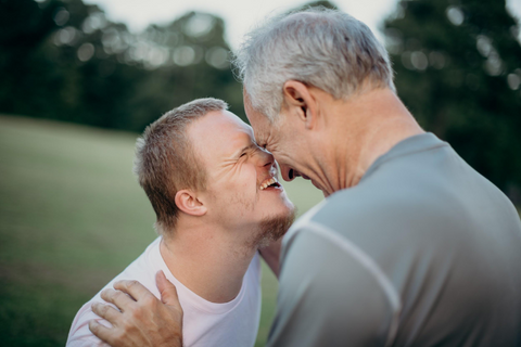 Down syndrome child and his father smiling