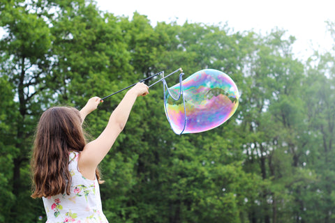 Little girl playing with bubbles