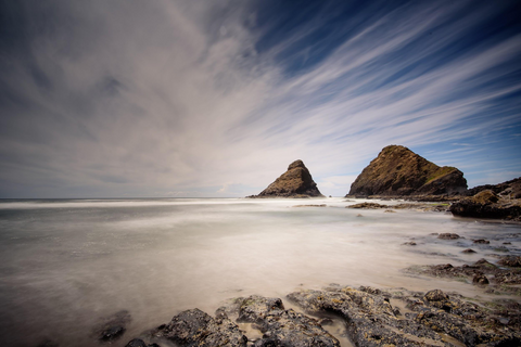 Rocky outcrop on a beach with blue skies above