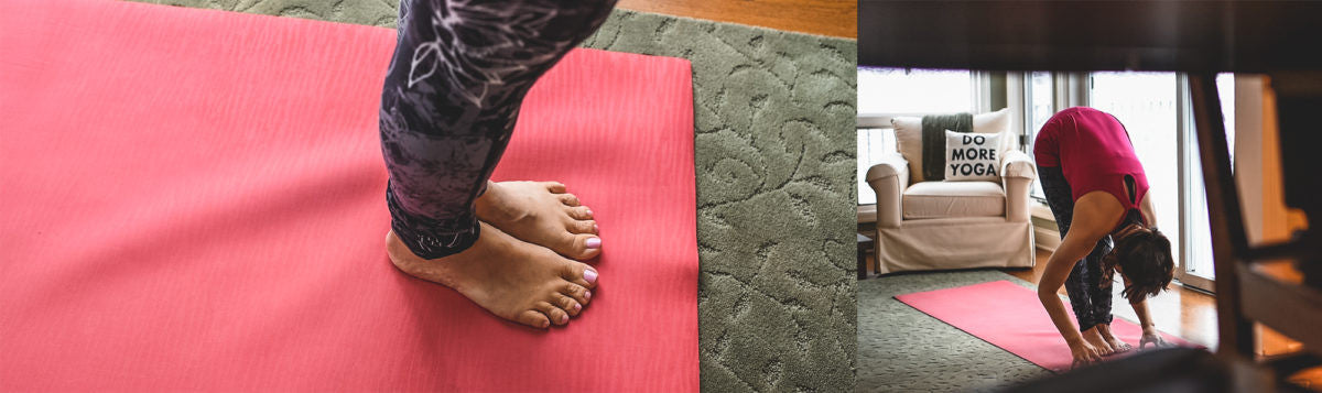 woman does a forward fold on her yoga mat