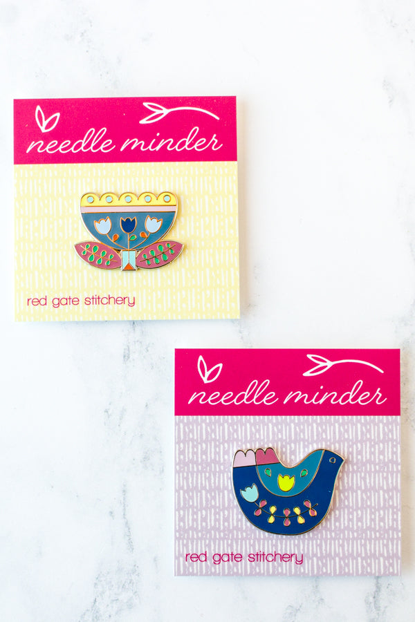 Folk art inspired enamel needle minders for cross stitch and embroidery