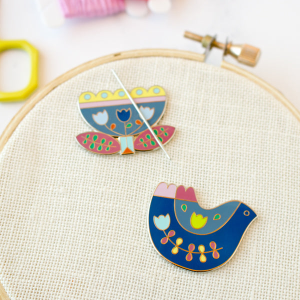 Folk art inspired enamel needle minders for cross stitch and embroidery