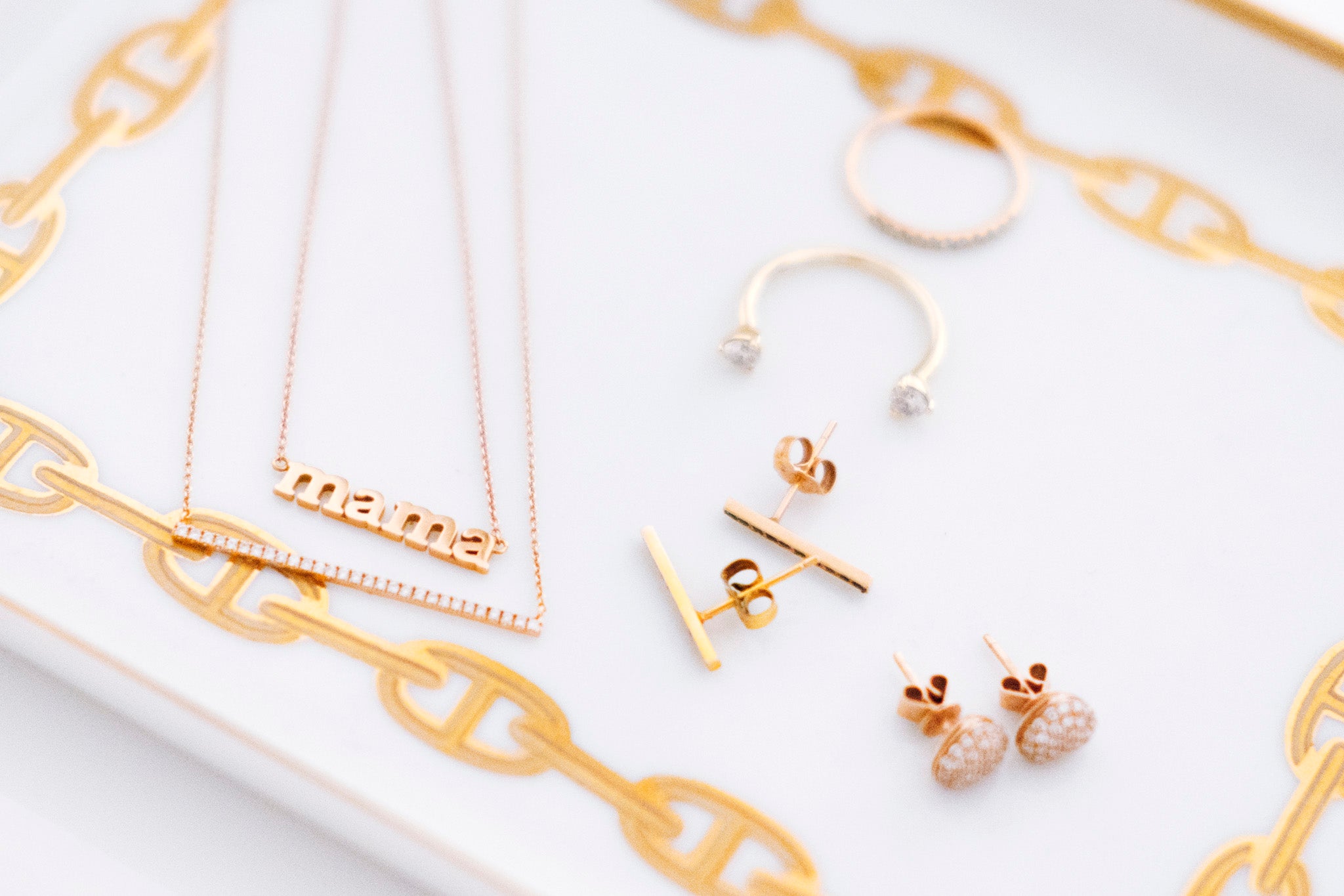 necklaces, earrings, and rings laid on gold and white plate for what's in my jewelry box