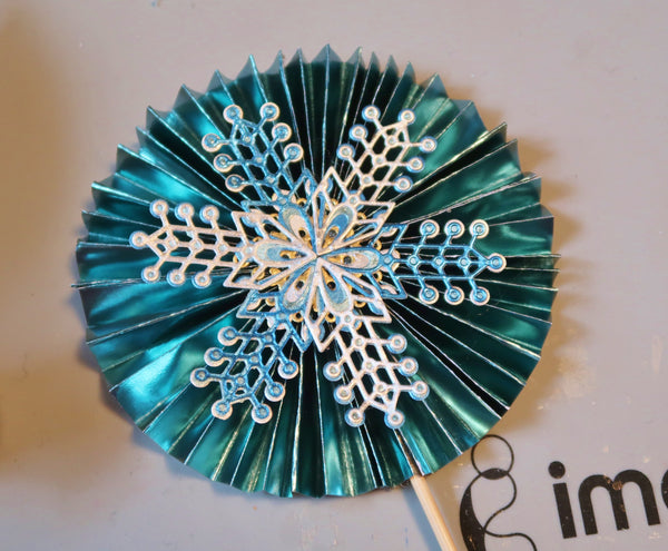  and use a hot glue gun to affix both sides of the rosette to the skewer. 
