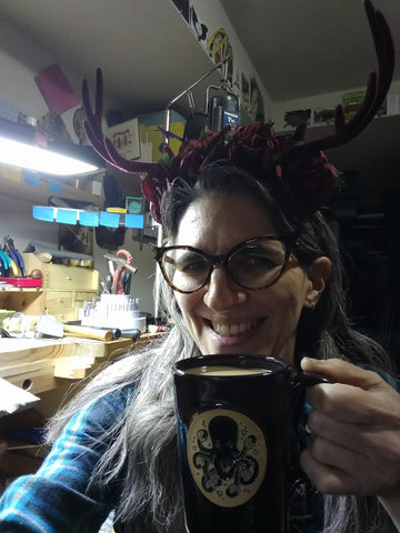 Natalia being silly and drinking coffee at her workbench