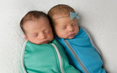 Twin babies sleeping in Merineo newborn swaddling bags