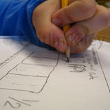 Close up photo of a child's hand drawing a solution to a math problem on a piece of paper