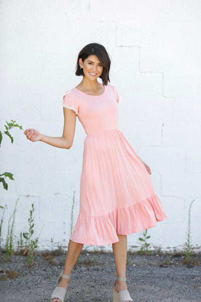 a young woman wears a full pink dress