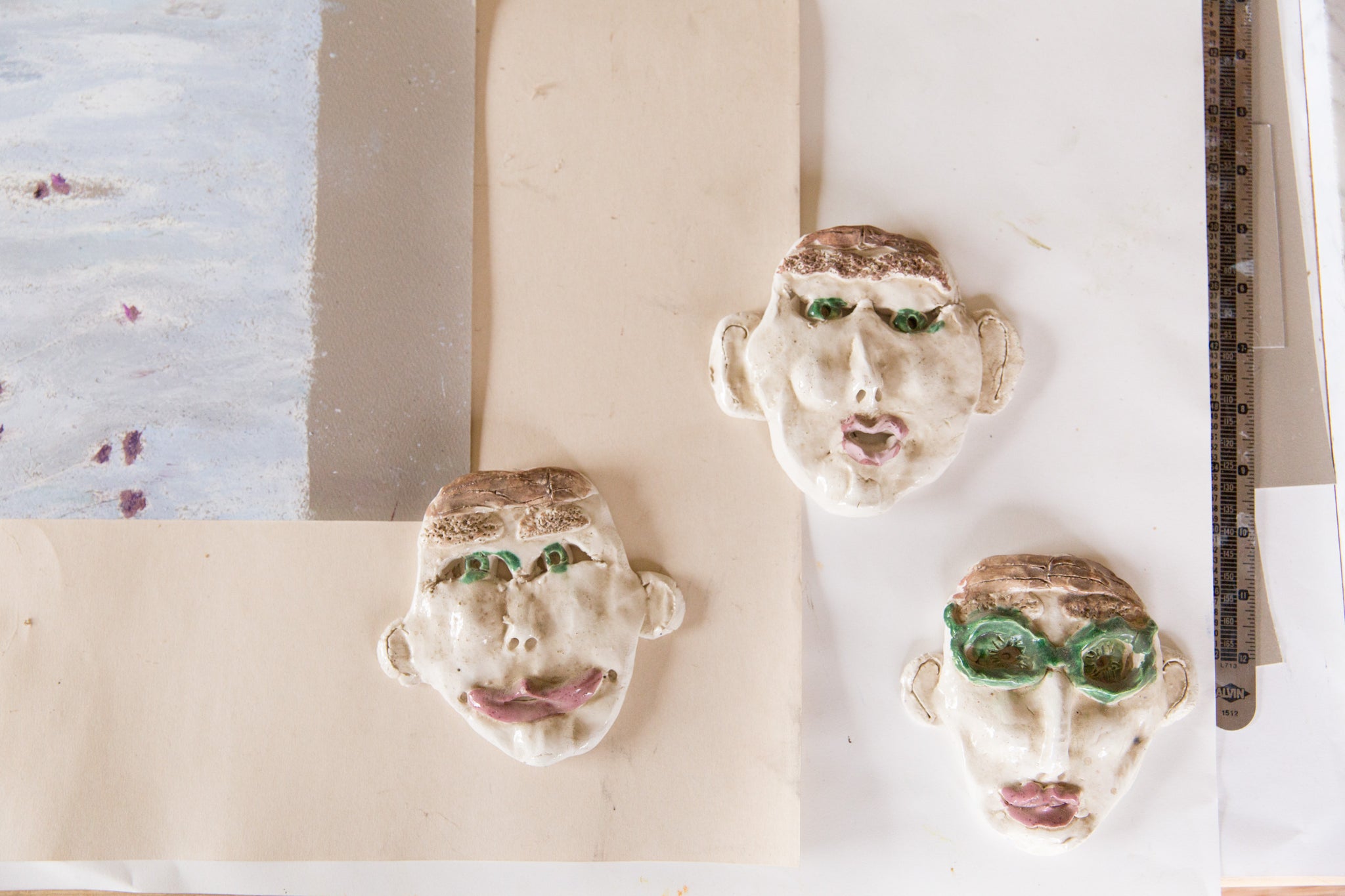 three ceramic faces on table