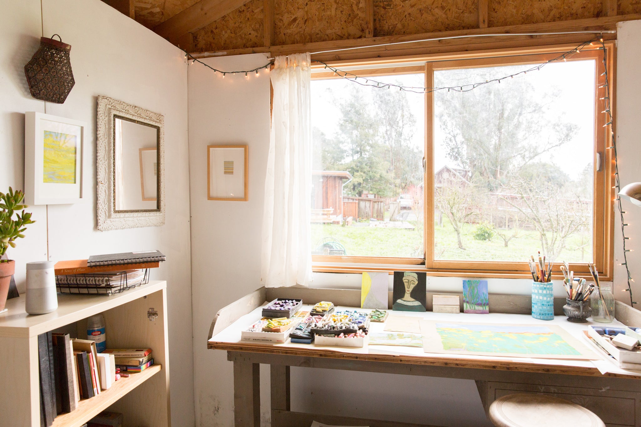 pastel artwork on table below windowsill