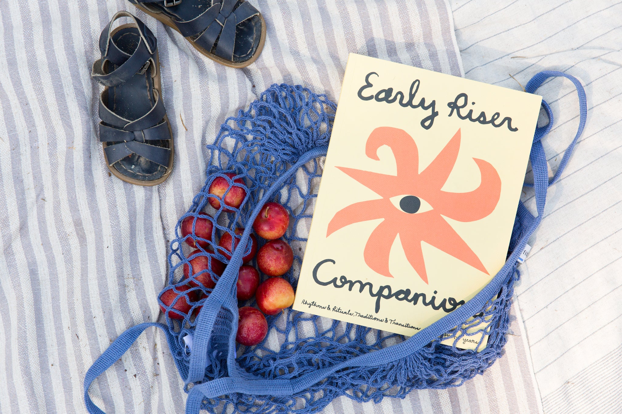 mini market bag with kid's sandals and "Early Riser Companion" book