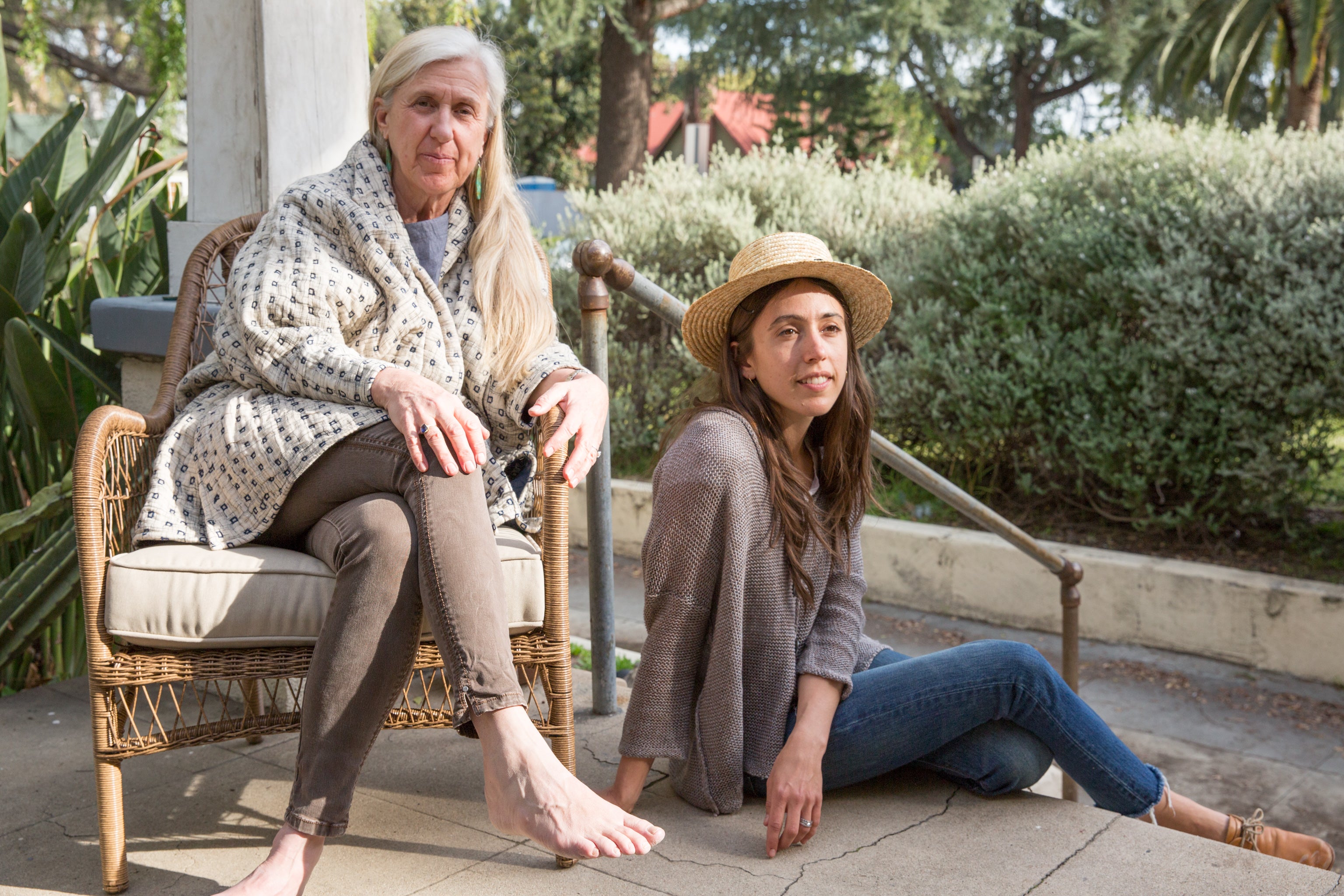 Dotter owners, Annika Huston and Susanne McLean, seated on porch, wearing Pavo jacket and Chalet sweater