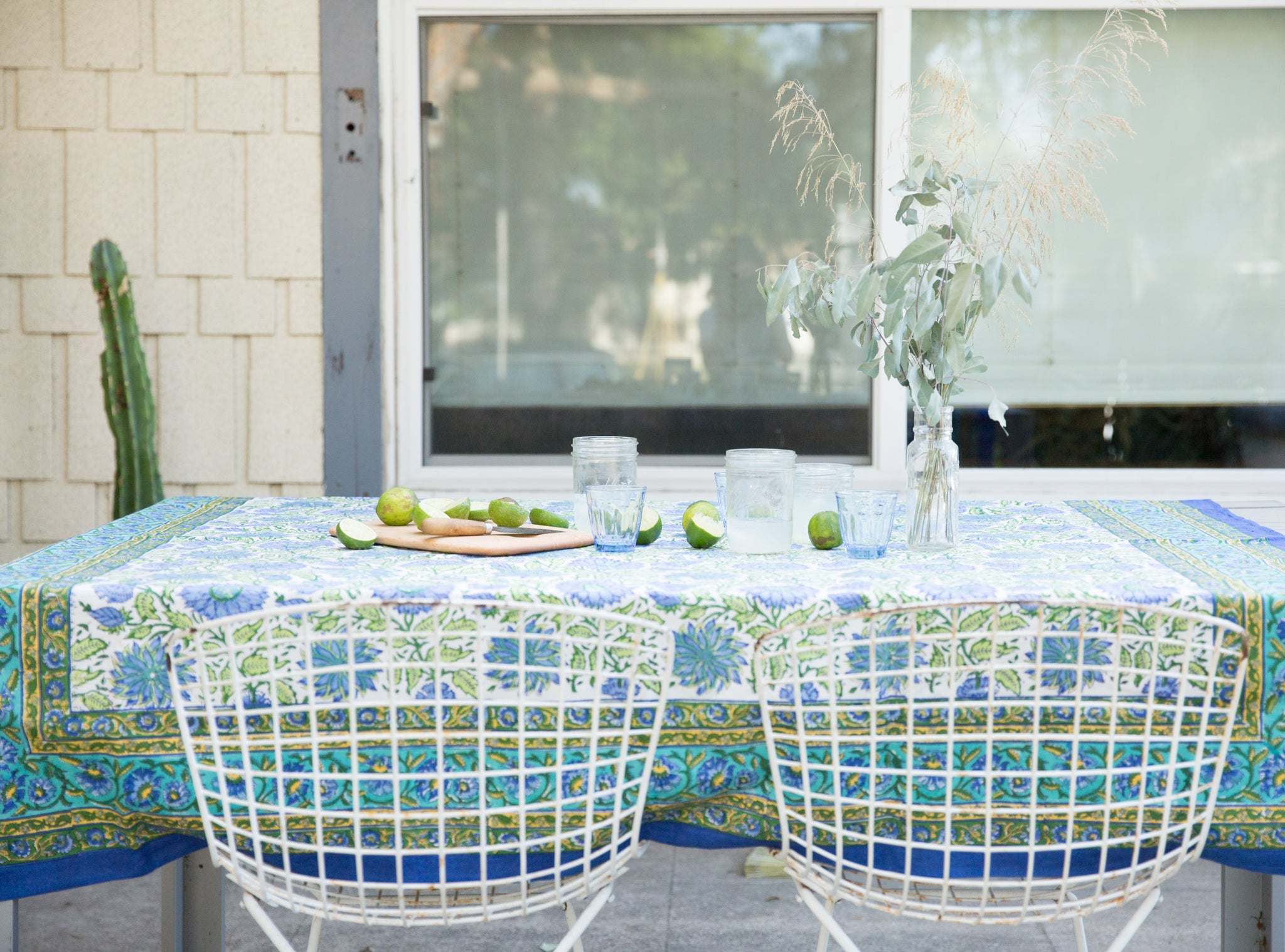 outdoor table with green and blue table cloth and limes