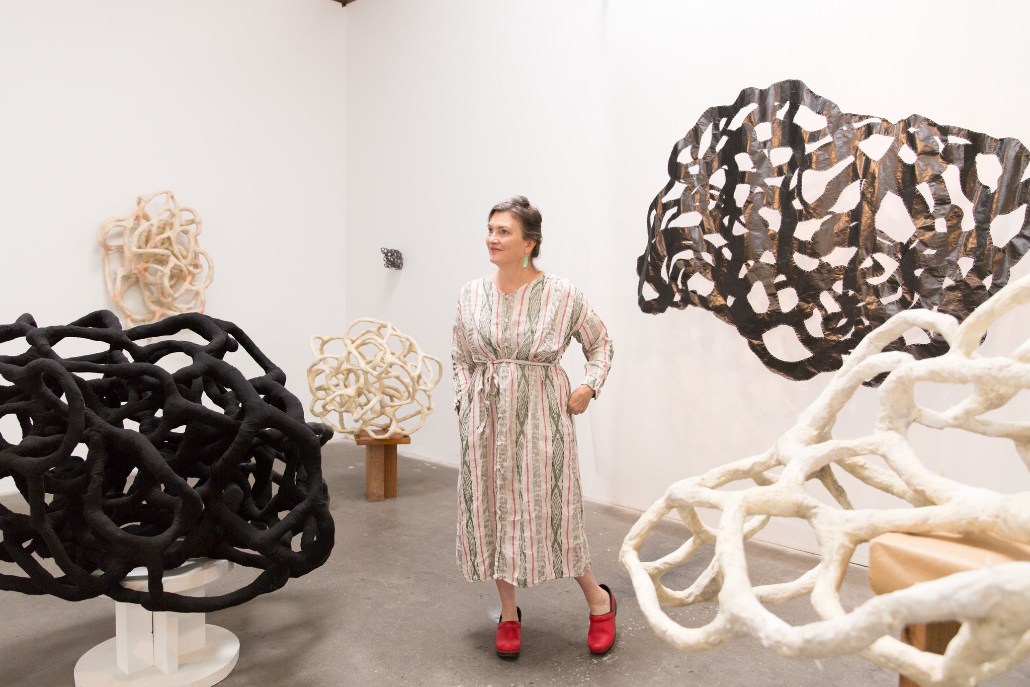 artist, Laura Cooper, surrounded by her sculptures in Los Angeles studio