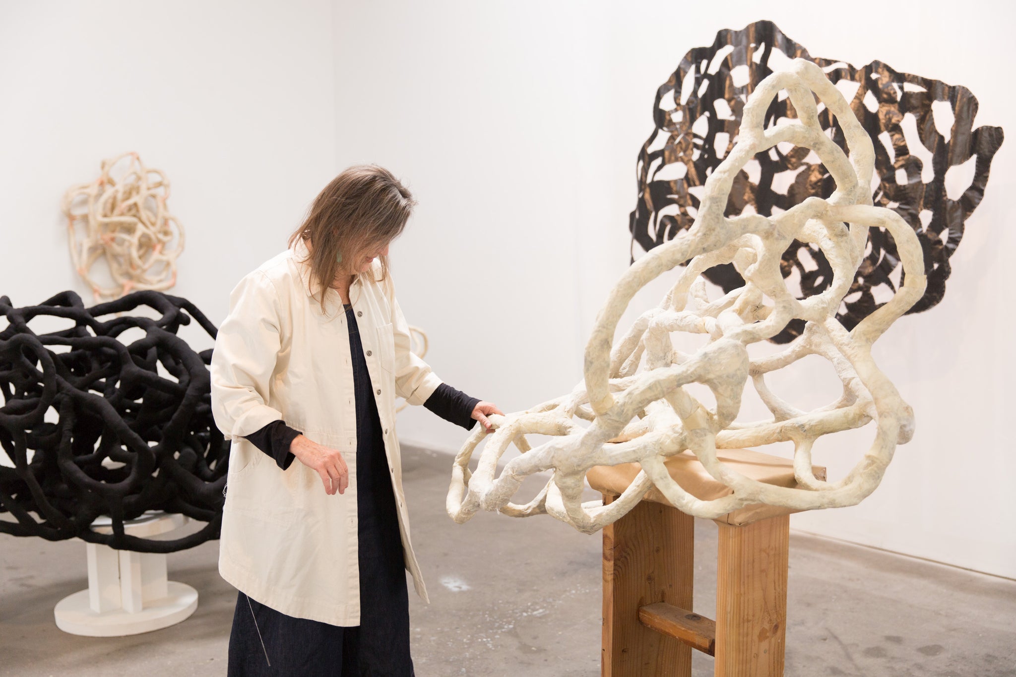 artist, Laura Cooper, touching her sculpture