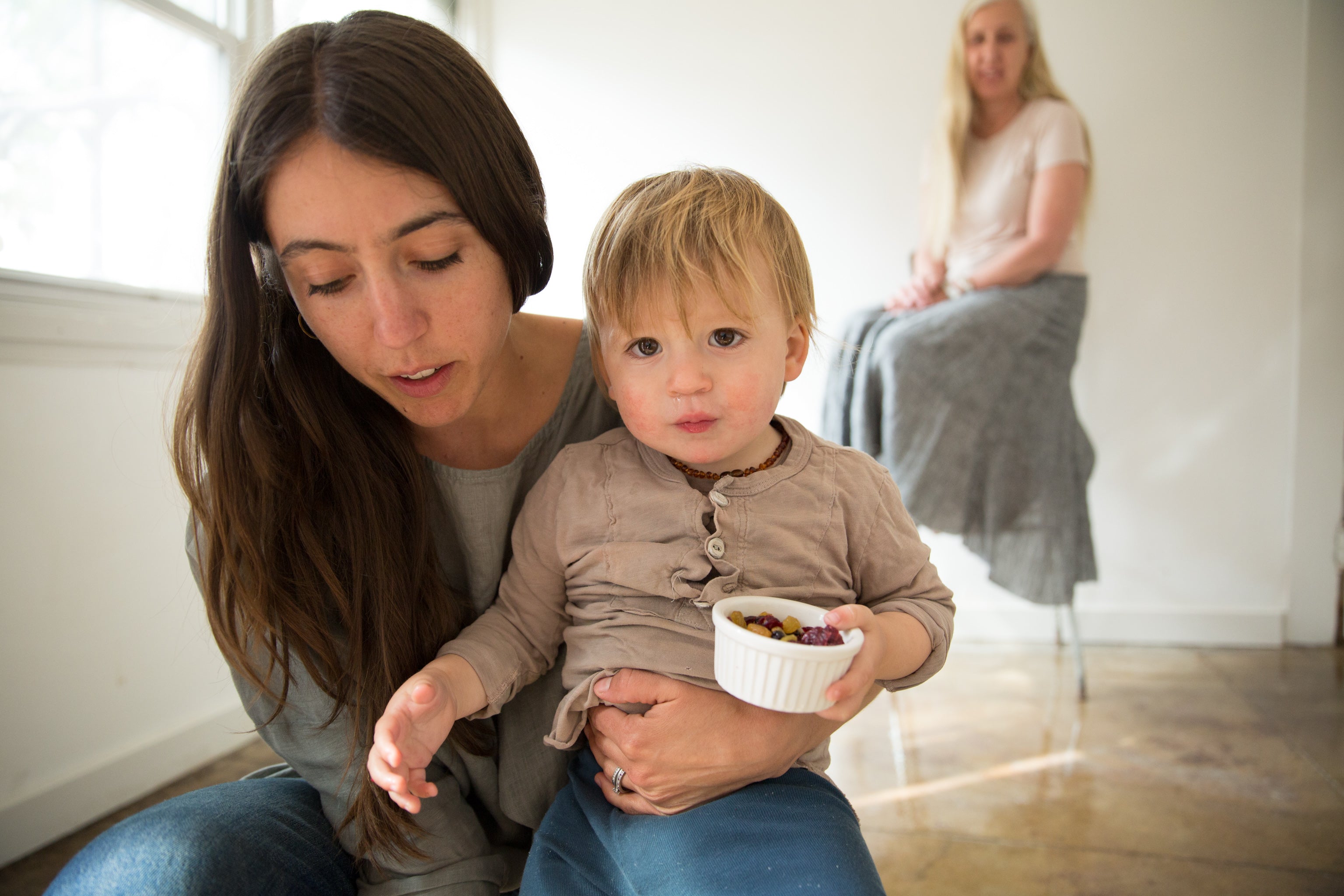 Dotter owner, Annika Huston, crouched with toddler son in foreground and mother, Susanne McLean seated in background
