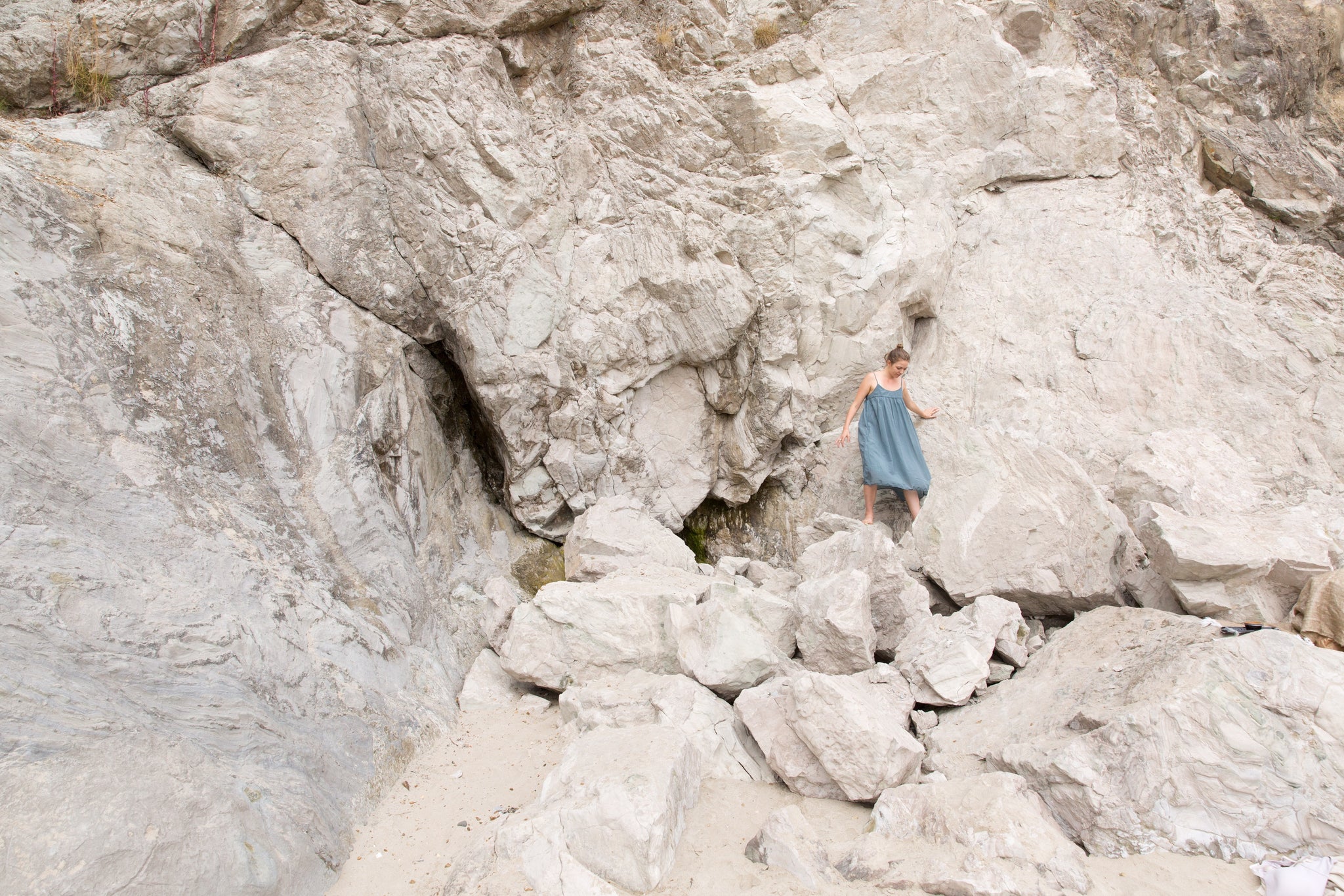 Portland musician, Hanna Haas, climbing on cliffs in CP Shades dress