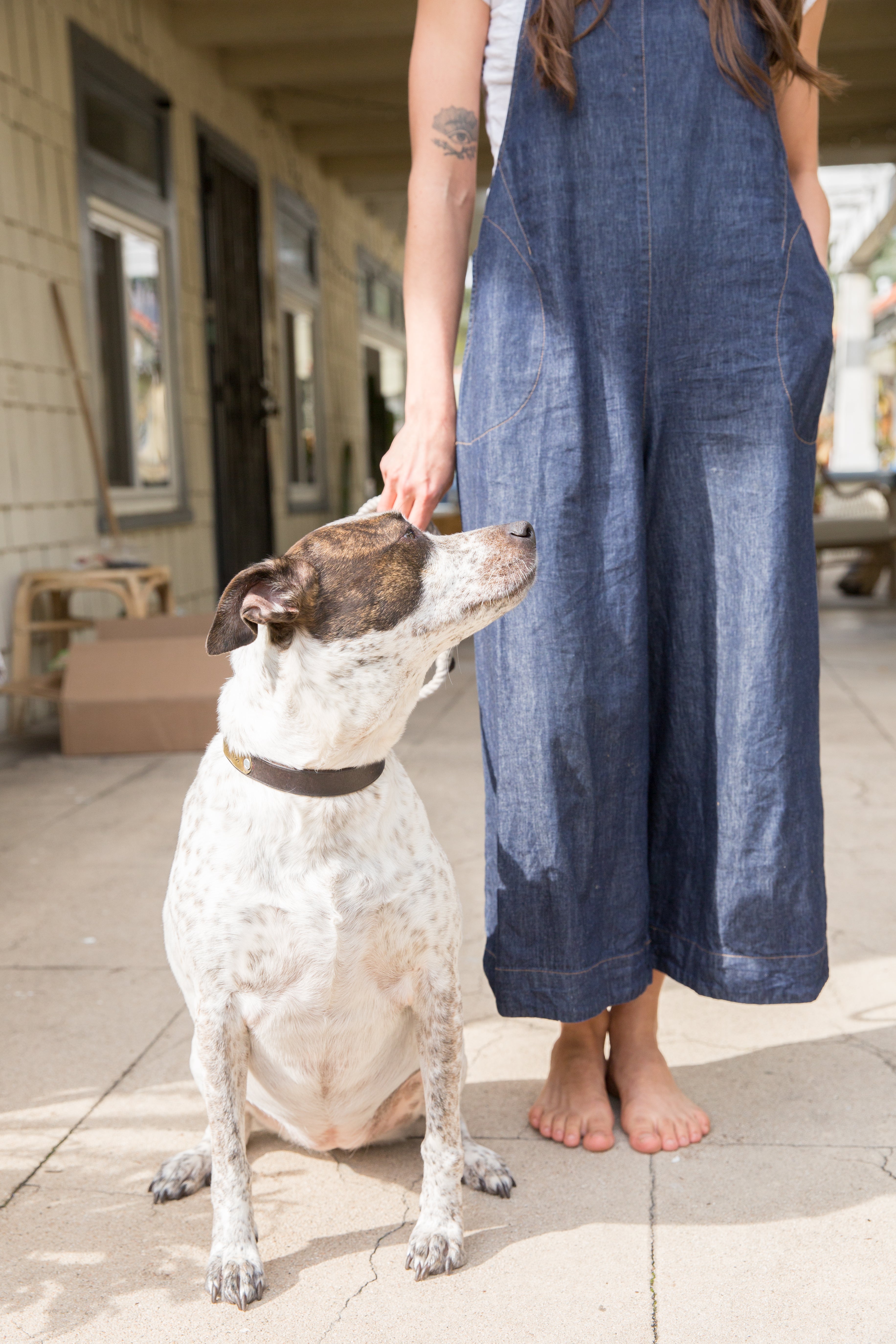 Annika Huston wearing denim jumpsuit with dog beside her