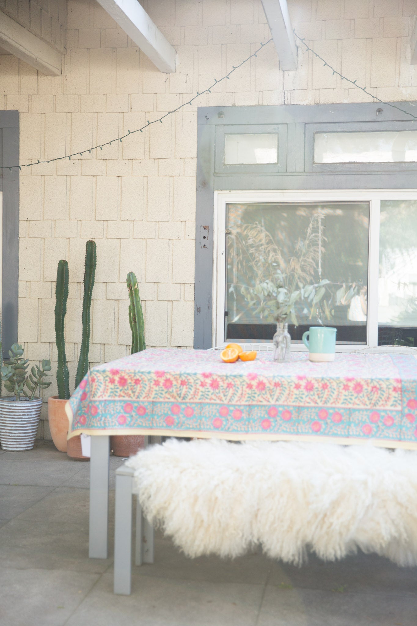 outdoor table with pink floral tablecloth and oranges