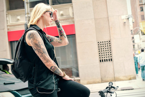 girl holding head on bike tattoed