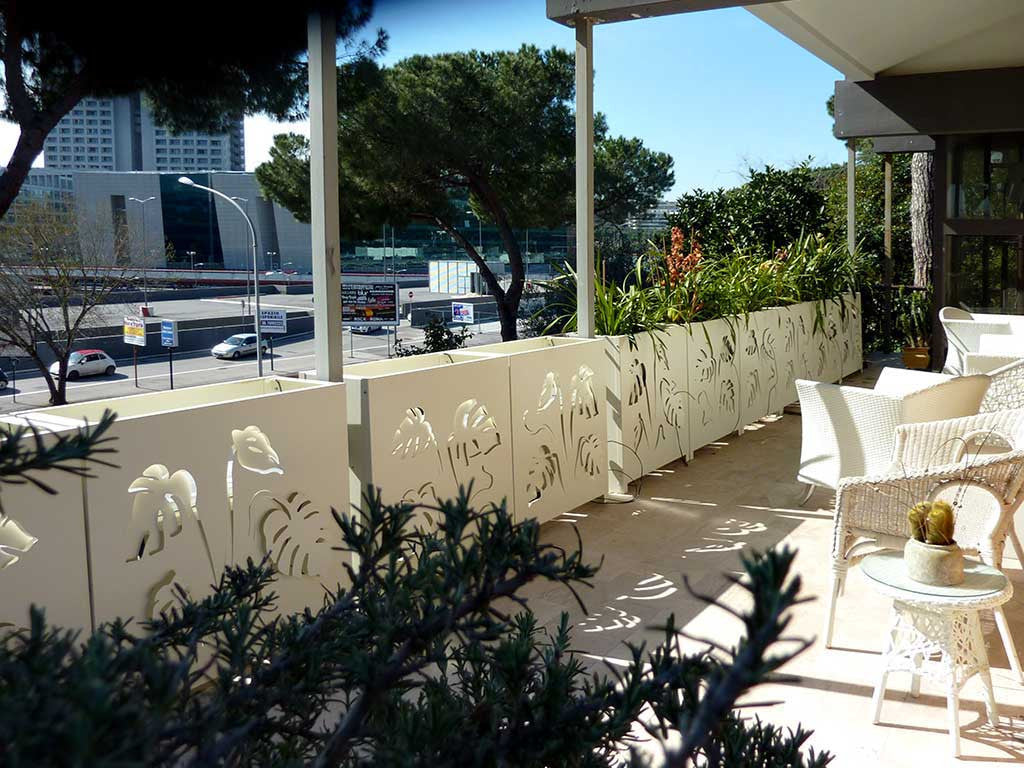 railing planters decorated on both sides with laser cut aluminum monstera leaves