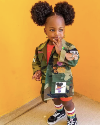 back to school hairstyles: young black girl with two cute afro puffs