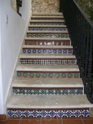 A different ceramic tile pattern is used on each row for this home staircase
