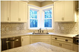 A bold cement tile pattern is muted with neutral colors and hues similar to the counter and cabinets.